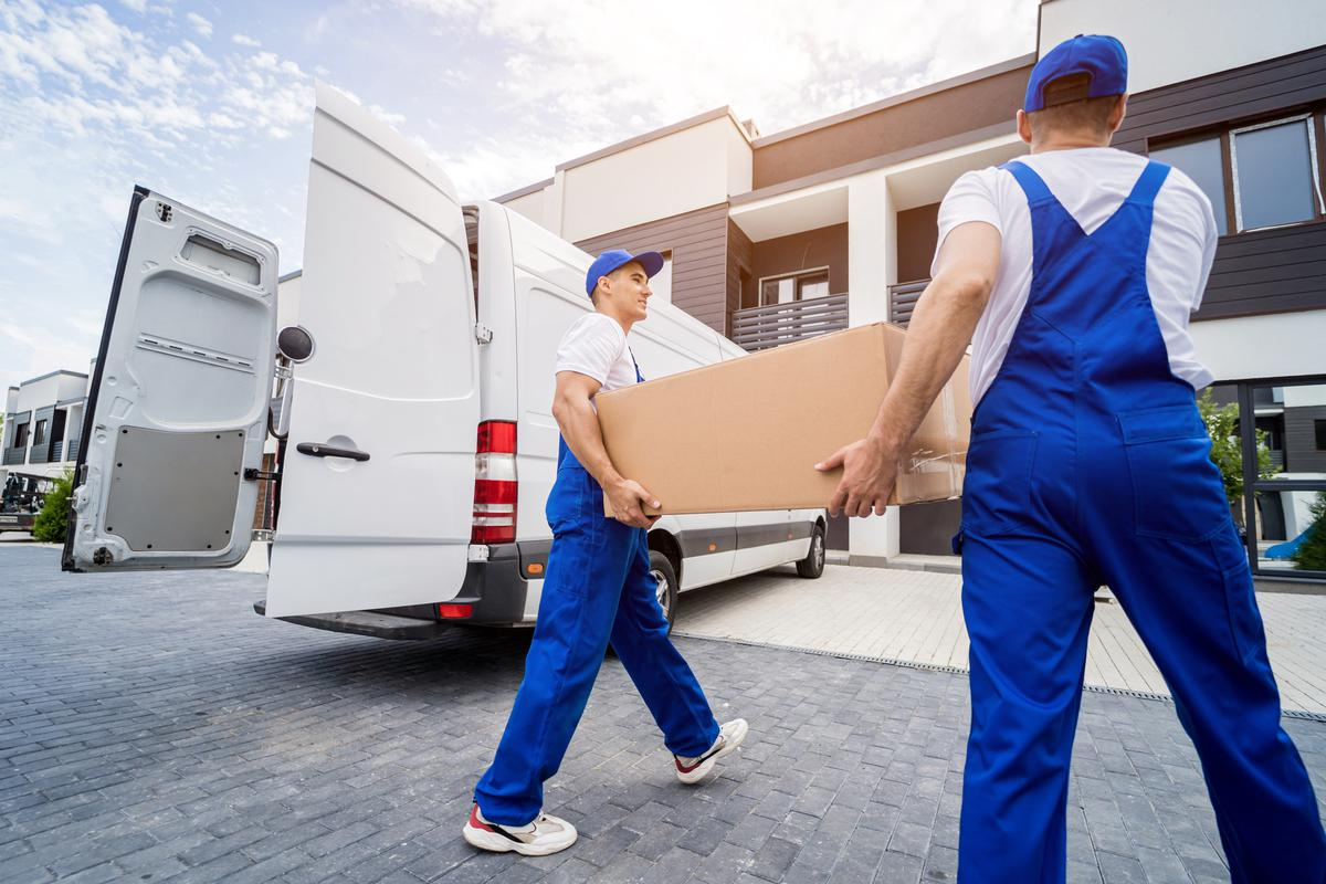 Professional movers carrying large box from van to home – Moving Pro Dallas