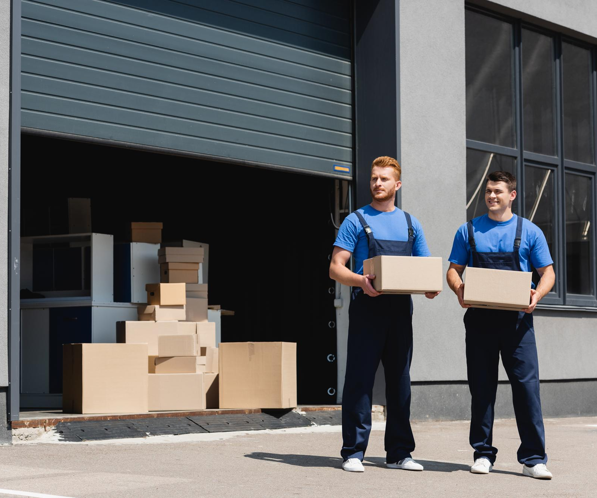 Moving crew handling boxes at storage facility entrance – Moving Pro Dallas